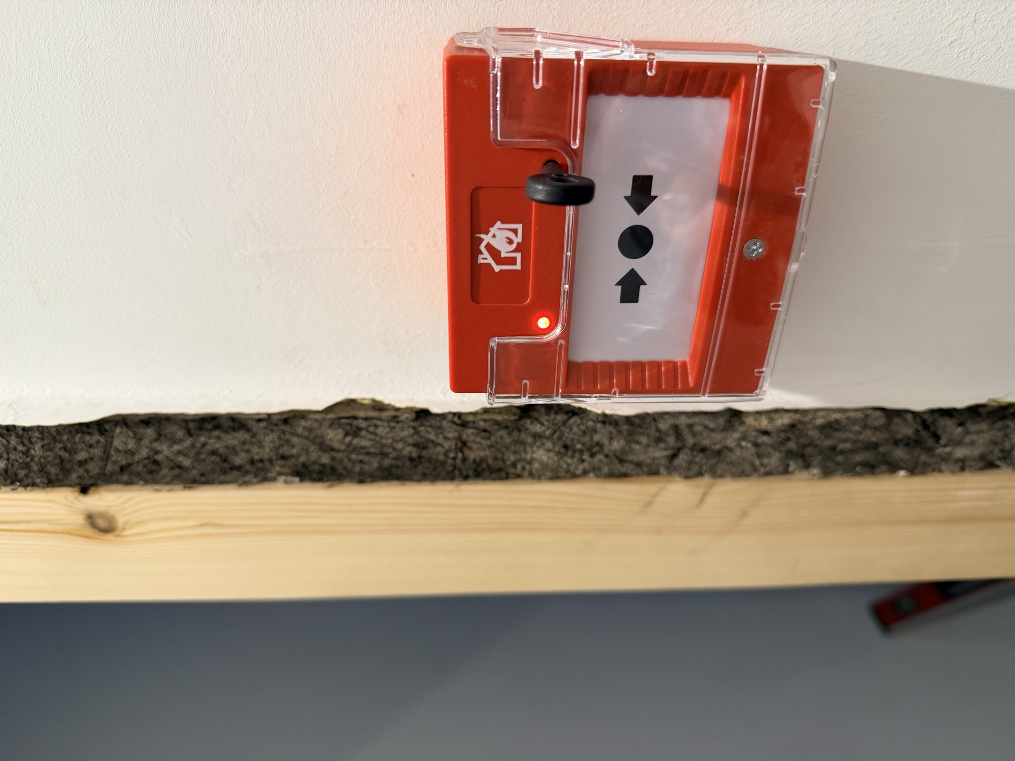 Fire alarm break-glass call point on an HMO wall in Greater Manchester